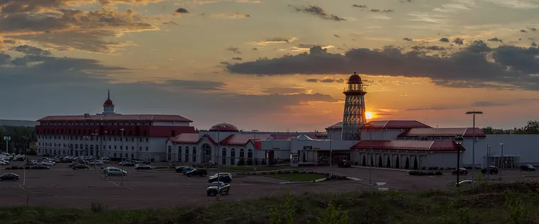 Casino New Brunswick in Moncton at sunset: the hotel block, the red-roofed casino wings and the lighthouse-style tower beyond the parking lot